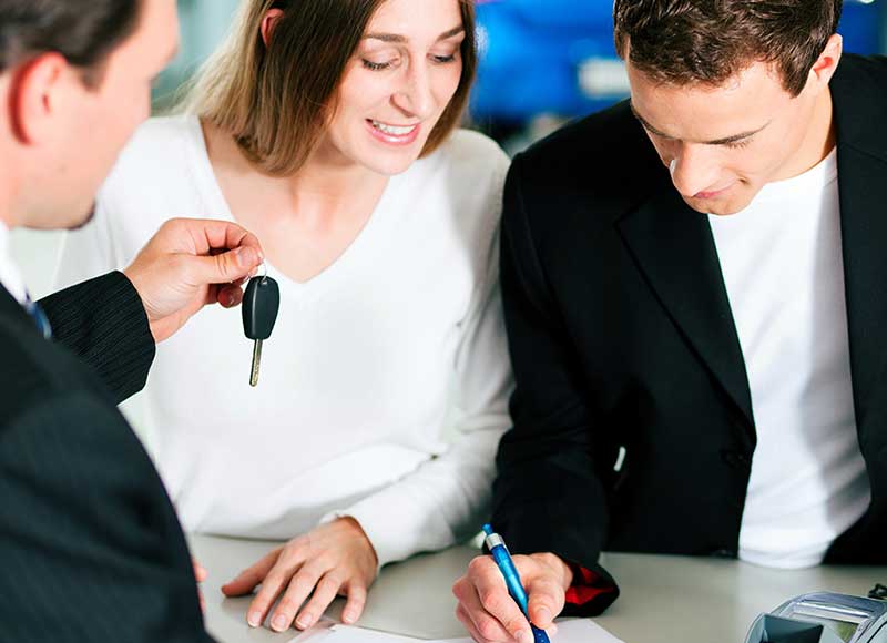 Customer completing car purchase paperwork at dealership